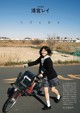 A woman in a school uniform riding a bike.