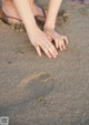 A person's feet in the sand on a beach.