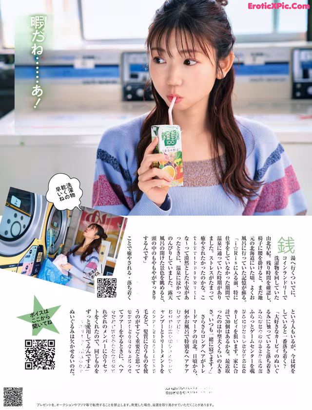 A woman holding a drink in front of a vending machine.