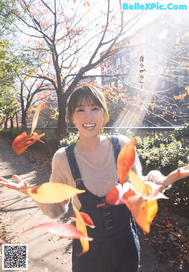 A woman holding a bunch of leaves in her hands.