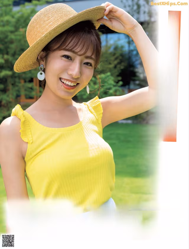 A woman in a yellow top and a straw hat.