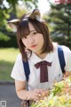 A woman in a school uniform with a cat ears headband.