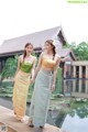 A couple of women standing next to each other near a pool.