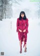 A woman in a red dress standing in the snow.