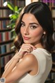 A beautiful young woman posing in front of a bookshelf.