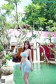 A woman in a blue bikini standing next to a pool.