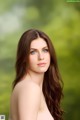 A woman with long brown hair and blue eyes posing for a picture.