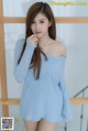 A woman in a blue sweater posing for a picture.